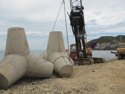 Những khối bê tông nặng 25 tấn đang được cẩu đặt lên thân đê.