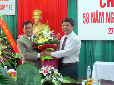 Đồng chí Nguyễn Hữu Hoài, Phó Bí thư Tỉnh uỷ, Chủ tịch UBND tỉnh tặng hoa chúc mừng lãnh đạo Trường Trung cấp Y tế Quảng Bình.