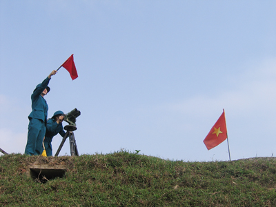 Đại đội trưởng Cao Thị Lê Na cầm cờ lệnh trên đài quan sát.