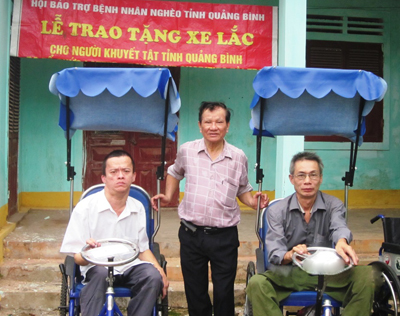 Chủ tịch Hội Phạm Quang Lịch trao tặng xe lắc cho người khuyết tật.
