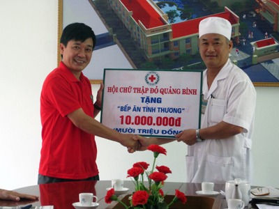 Ông Phan Văn Cầu, Phó Chủ tịch Hội CTĐ tỉnh  trao số tiền 10 triệu đồng cho lãnh đạo Bệnh viện   đa khoa huyện Quảng Ninh.