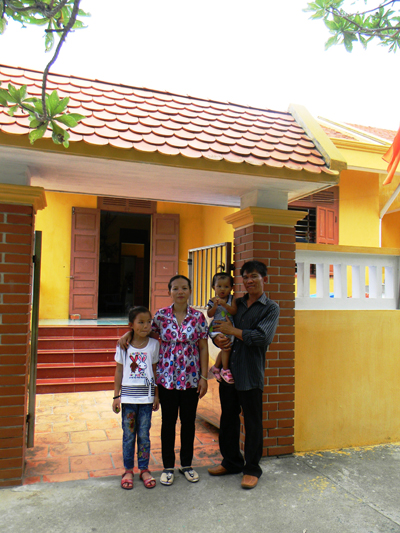 Gia đình anh anh Hồ Văn Hiền và chị Ngô Thị Kim Úy bên ngôi nhà mới khang trang ở đảo Sinh Tồn.