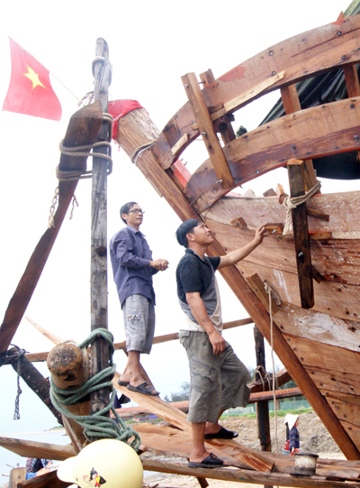 Ông Phạm Minh Hồng (người bên trái) và con tàu đang đóng dở.