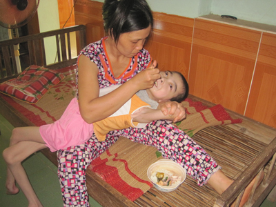 Chị Mai đang cho em Trinh Nương ăn cơm.