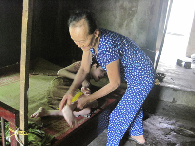 Bà Mai đang chăm sóc người con trai út Trần Văn Tâm nằm liệt giường từ hơn 30 năm nay.