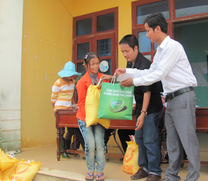 Đại diện Công ty TNHH Bia Huế và Báo Thanh niên trao quà cho các gia đình ở xã Ngư Thuỷ Bắc.