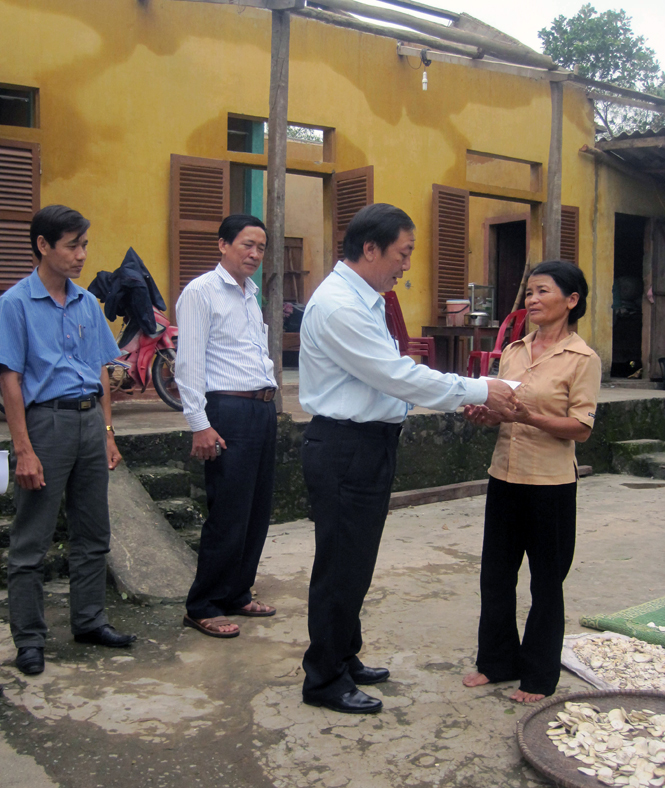 Ông Ngô Hồng Quân, Phó Bí thư Huyện ủy Quảng Ninh tặng quà cho gia đình ông Ngô Văn Đôn tại thôn Rào Trù, xã Trường Xuân.