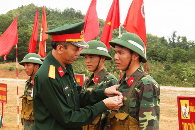 Đại tá Nguyễn Đức Hóa-nguyên Chính ủy BCHQS tỉnh tặng hoa bắn giỏi ở thao trường.