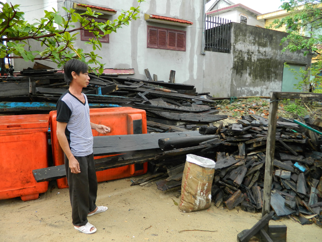 Anh Nguyễn Chí Liên bên “con tàu” vỡ vụn sau bão.