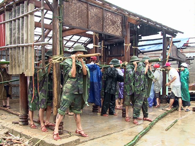 Cán bộ chiến sĩ Trung đoàn 996 giúp người dân Quảng Sơn khắc phục hậu quả thiên tai.