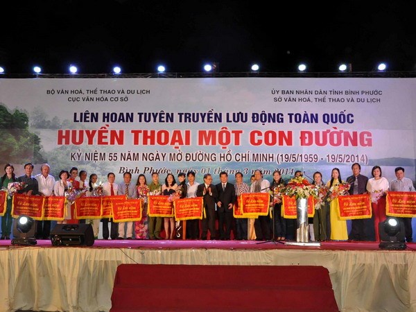 Ban Tổ chức tặng hoa và trao cờ lưu niệm cho các đoàn tham gia liên hoan kỷ niệm 55 năm Đường Hồ Chí Minh. (Ảnh: Đậu Tất Thành/TTXVN)