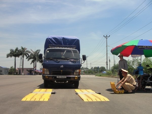 Lực lượng liên ngành kiểm tra tải trọng xe qua trạm cân lưu động. (Ảnh: Việt Hùng/Vietnam+)