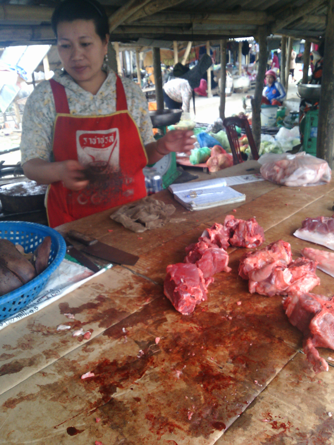 Một quầy bán thịt tại chợ Cưởi, xã Thanh Thủy (Lệ Thủy), thịt lợn được bày trên tấm bìa cattong cáu bẩn để bán cho khách hàng.