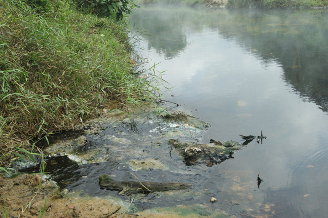 Nguồn nước bị ô nhiễm đen ngòm ở suối Bang.