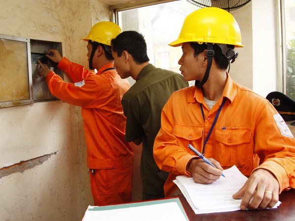 Công nhân Tổng công ty Điện lực thành phố Hà Nội chốt chỉ số côngtơ. (Ảnh: Ngọc Hà/TTXVN)
