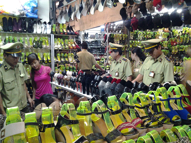 Lực lượng quản lý thị trường kiểm tra việc niêm yết giá tại các quầy hàng kinh doanh giày dép chợ Đồng Hới.