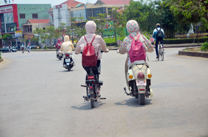 Tình trạng học sinh điều khiển xe đạp điện không đội mũ bảo hiểm khá phổ biến ở Đồng Hới.