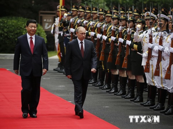 Chủ tịch Trung Quốc Tập Cận Bình (trái) và Tổng thống Nga Vladimir Putin (giữa) duyệt đội danh dự trong lễ đón ở Thượng Hải. (Nguồn: AFP/TTXVN)