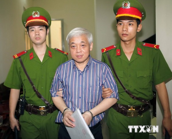 Cảnh sát dẫn giải bị cáo Nguyễn Đức Kiên vào phòng xử án. (Ảnh: Doãn Tấn/TTXVN)