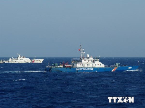 Tàu hải cảnh Trung Quốc (bên trái) đeo bám tàu Cảnh sát biển Việt Nam đang làm nhiệm vụ. (Ảnh: Công Định-Hữu Trung/TTXVN)