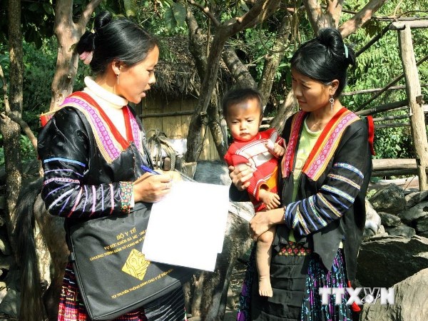 Cô đỡ thôn bản tại tỉnh Điện Biên hướng dẫn người dân cách chăm sóc sức khỏe cho người mẹ và trẻ nhỏ. (Ảnh: TTXVN)