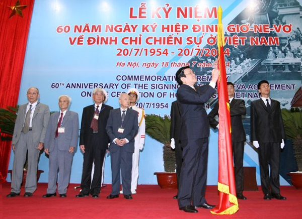 Chủ tịch nước Trương Tấn Sang gắn huy hiệu Anh hùng Lực lượng vũ trang nhân dân lên Cờ truyền thống của Đoàn Chính phủ Việt Nam Dân chủ cộng hòa tại Hội nghị Geneva năm 1954. (Ảnh: Thống Nhất/TTXVN)