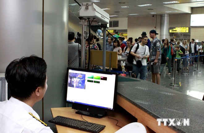 Sử dụng máy đo thân nhiệt tia hồng ngoại nhằm kiểm soát dịch bệnh ở sân bay Nội Bài. (Ảnh: Dương Ngọc/TTXVN)