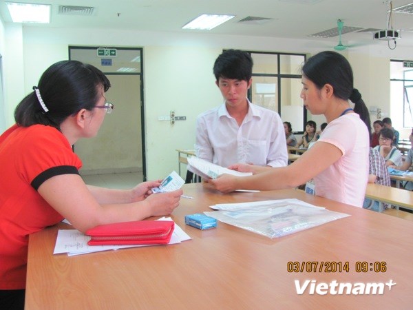 Thí sinh làm thủ tục dự thi tại Học viện Công nghệ Bưu chính Viễn thông. (Ảnh: Phạm Mai/Vietnam+)