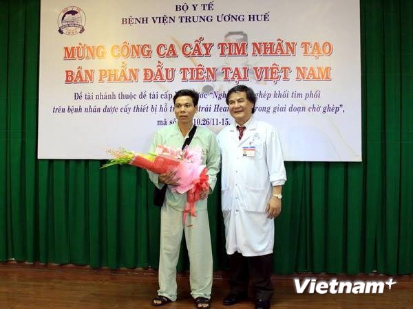 Giáo sư, tiến sĩ Bùi Đức Phú tặng hoa cho bệnh nhân Hoàng Quốc Biên ngày xuất viện. (Ảnh: Quốc Việt/Vietnam+)