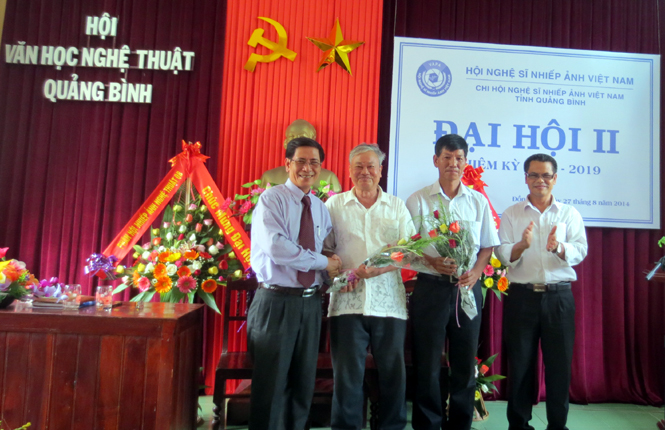 NSNA Phạm Văn Tý, Phó Chủ tịch Hội Nghệ sĩ Nhiếp ảnh Việt Nam tặng hoa cho các thành viên Ban chấp hành Chi hội nhiệm kỳ 2014-2019