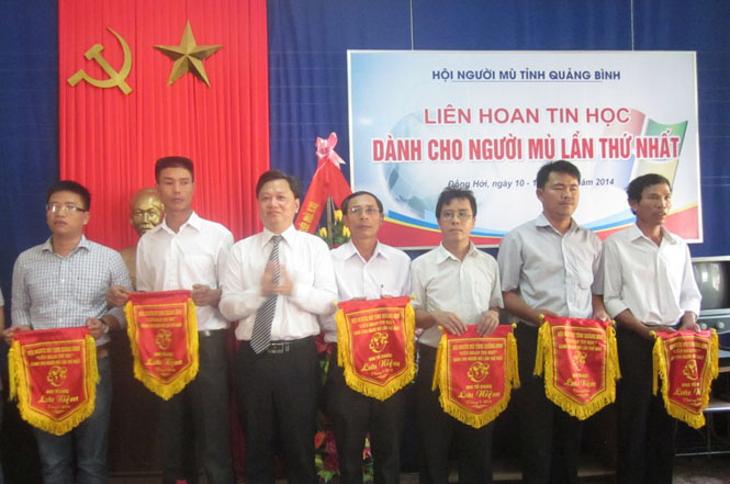 Đồng chí Nguyễn Tiến Hoàng, TUV, Phó Chủ tịch UBND tỉnh trao cờ lưu niệm cho đại diện các Hội Người mù huyện, thành phố trong tỉnh.