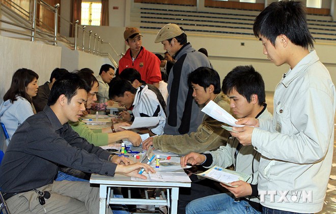 Người lao đông nộp hồ sơ đăng ký dự thi tiếng Hàn tại Trung tâm Giới thiệu việc làm Hà Nội. (Ảnh : Hữu Việt/TTXVN)