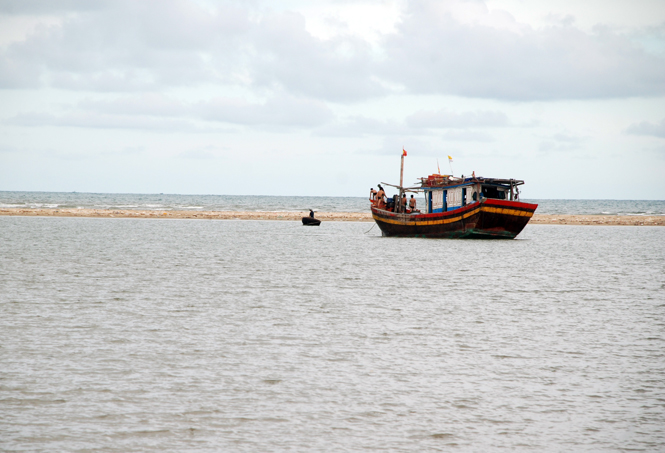 Một tàu cá của ngư dân Quảng Phú mắc cạn tại cửa sông Roòn  khi tìm cách vào neo đậu, cuối tháng 8-2014.