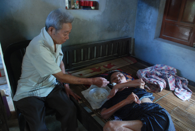 Gần 30 năm vợ liệt giường, ông Vành đều bón từng muỗng cơm  cho bà Xuân ăn.