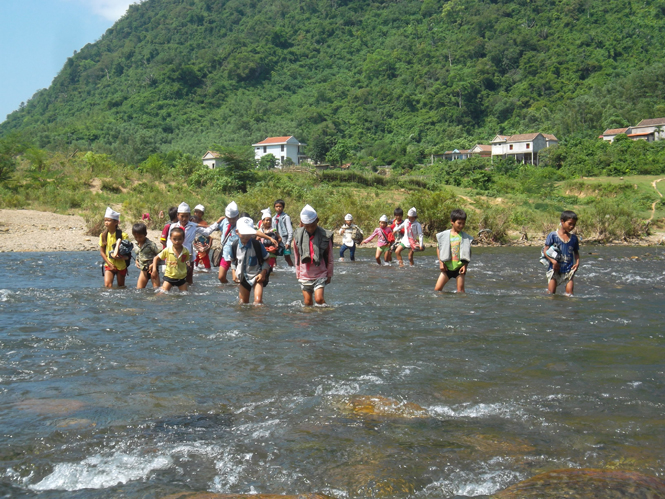 Học sinh các bản Cây Sú, Long Sơn lội cắt sông Long Đại đến trường.