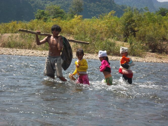 Hồ Văn Dưng, tranh thủ thời gian nghỉ đón con lội sông về nhà.