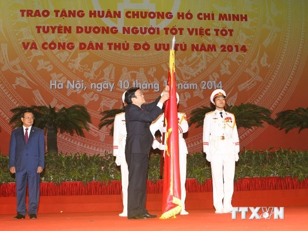 Chủ tịch nước Trương Tấn Sang gắn Huân chương Hồ Chí Minh lên lá cờ truyền thống của Thủ đô Hà Nội (Ảnh: Trí Dũng/TTXVN)