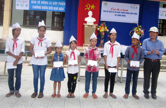 Đại diện BQL Dự án Hỗ trợ chuẩn bị sẵn sàng thực hiện REDD+ tại Quảng Bình trao giải cho các em học sinh.