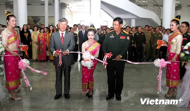 Đại sứ Nguyễn Mạnh Hùng và Trung tướng Souvon cắt băng khai mạc triển lãm ảnh về Quân tình nguyện Việt Nam. (Nguồn: Hoàng Chương/Vietnam+)