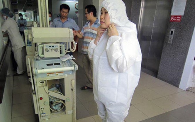 Các nhân viên y tế Bệnh viện Đà Nẵng mang áo quần bảo hộ trước khi tiếp xúc bệnh nhân.  (Ảnh: Báo Tuổi trẻ).