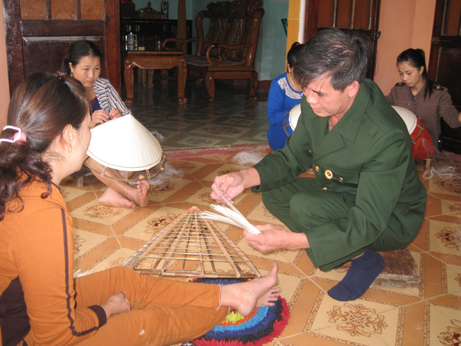 CCB Hoàng Hữu Tố đang hướng dẫn bà con cách đan mẫu nón mới.