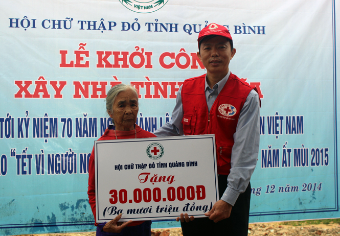 Ông Cao Quang Cảnh, Chủ tịch Hội CTĐ tỉnh trao số tiền tượng trưng cho mẹ liệt sỹ Lê Thị Nuôi
