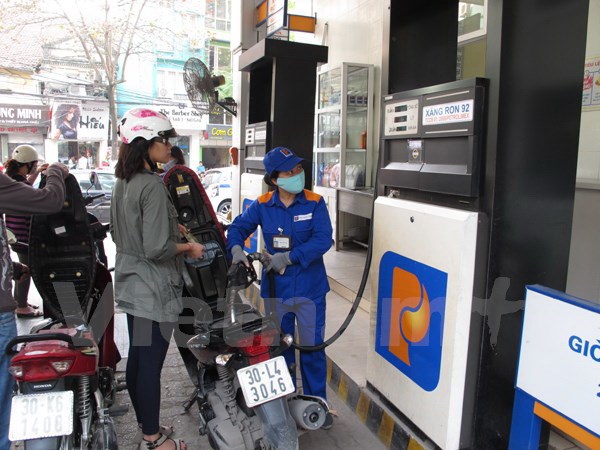 Nhân viên cửa hàng xăng dầu của Petrolimex đang bán xăng cho khách hàng (Ảnh: Đức Duy/Vietnam+)