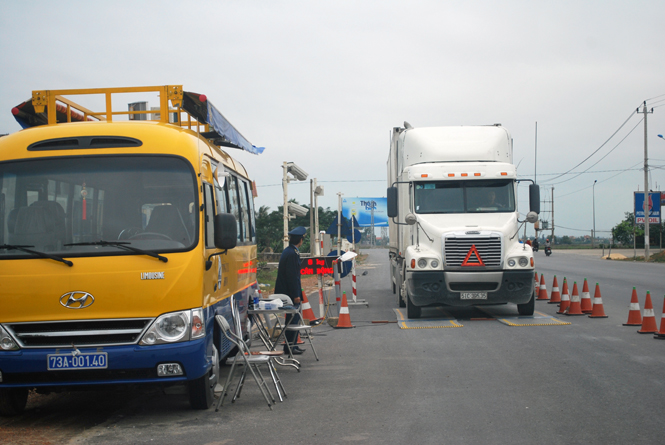 Lực lượng liên ngành đang kiểm tra tải trọng xe trên quốc lộ 1, đoạn qua huyện Bố Trạch.