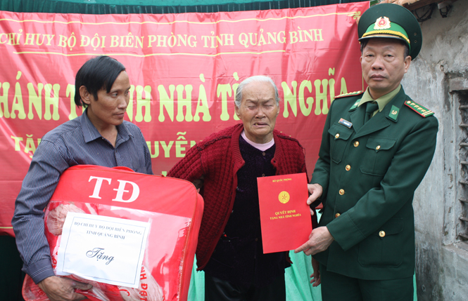 Đại tá Vũ Mạnh Lượng, Chính ủy BĐBP Quảng Bình trao quà và giấy chứng nhận nhà tình nghĩa cho bà Nguyễn Thị Đói.