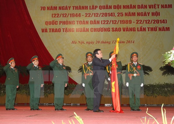 Chủ tịch nước Trương Tấn Sang gắn Huân chương Sao Vàng lên lá cờ truyền thống của Quân đội nhân dân Việt Nam. (Ảnh: Trí Dũng/TTXVN)