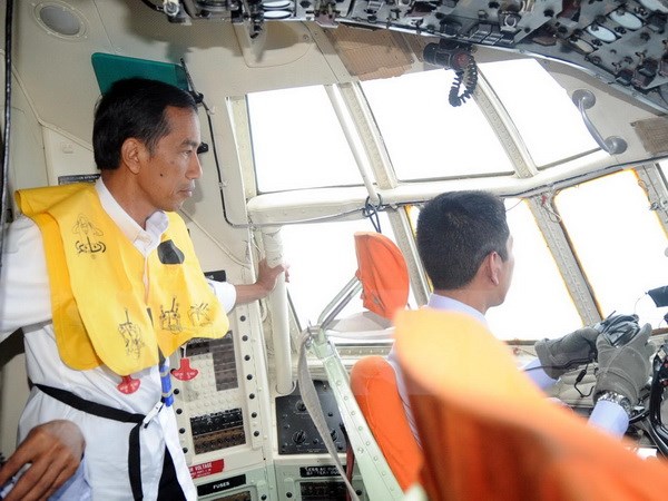 Tổng thống Indonesia Joko Widodo (trái) trong chuyến bay thị sát khu vực phát hiện máy bay QZ8501 ngày 30-12. (Ảnh: AFP/TTXVN)