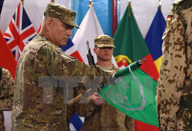 Tư lệnh các lực lượng Mỹ và NATO tại Afghanistan, Tướng John Campbell (trái) hạ cờ tại buổi lễ ở Kabul. (Nguồn: AFP/TTXVN)