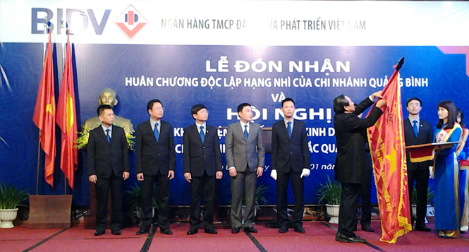 Thừa ủy quyền của Chủ tịch nước, đồng chí Hoàng Đăng Quang, Phó Bí thư Thường trực Tỉnh ủy, Trưởng đoàn đại biểu Quốc hội tỉnh trao Huân chương Độc lập hạng Nhì cho BIDV Quảng Bình.