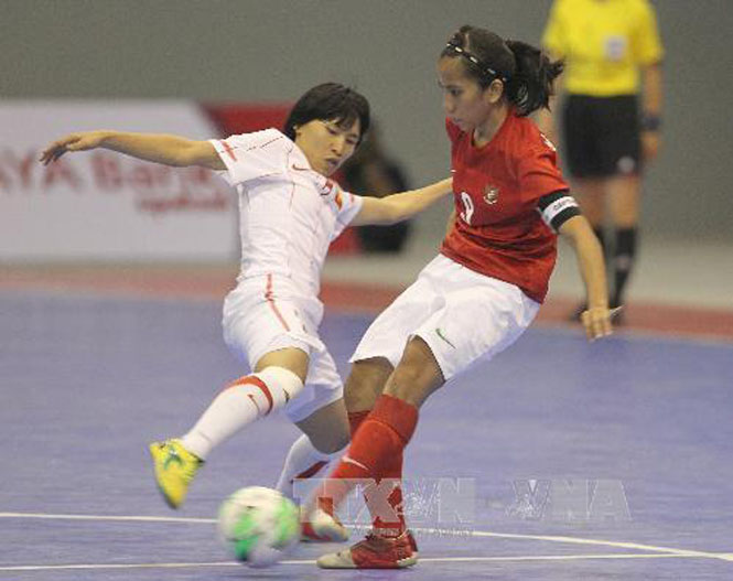  Pha tranh bóng giữa 2 nữ cầu thủ Futsal trong kì thi Sea Games 27. Ảnh: Quang Nhựt - TTXVN.